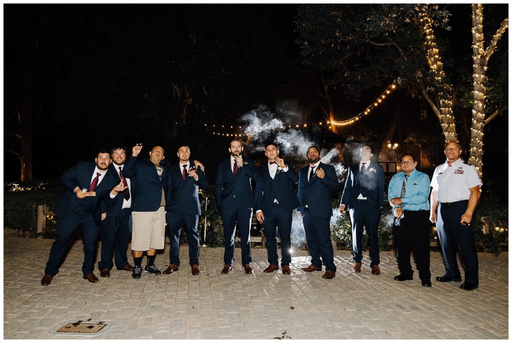 groomsmen smoking at wedding reception