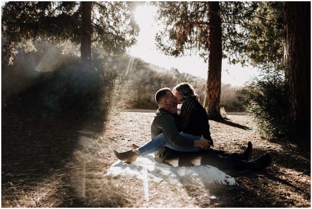 couple sitting on ground and kissing