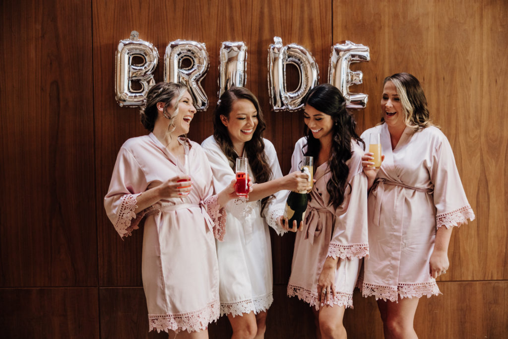 Luce loft wedding bridesmaids popping champagne