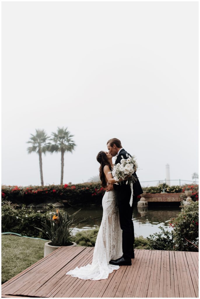 bride and groom kissing, california wedding venue, bride and groom by palm trees