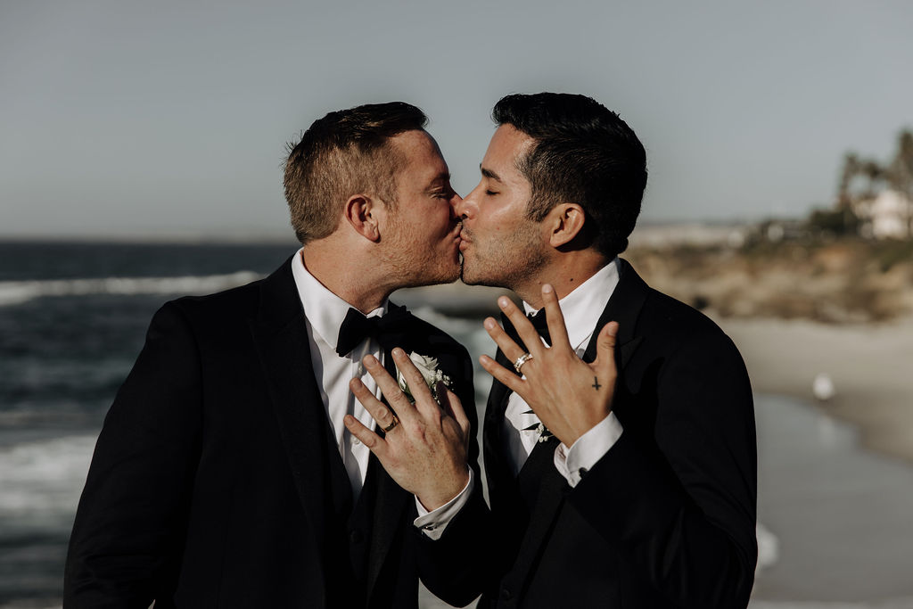 grooms kissing and showing rings