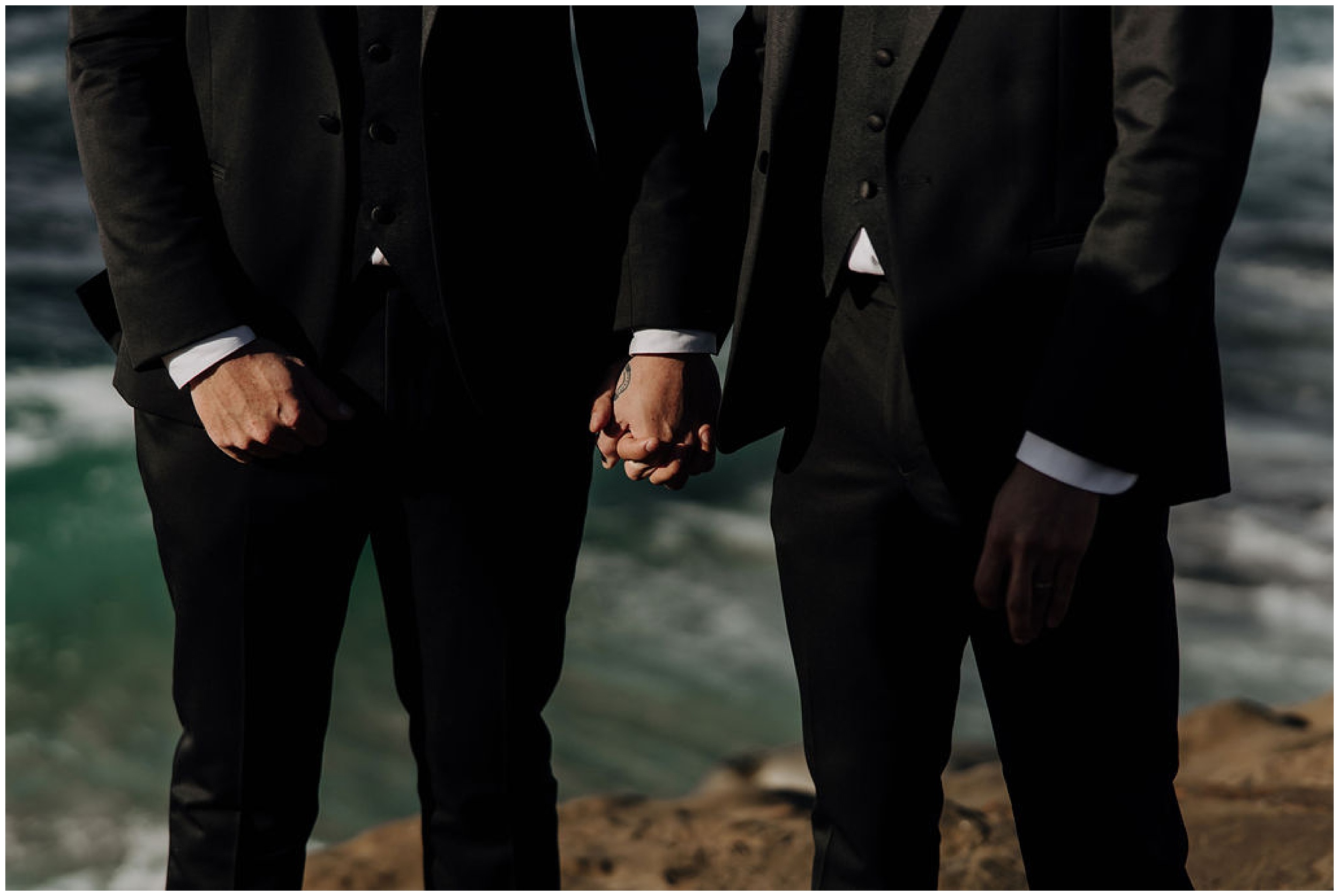 grooms holding hands on wedding day
