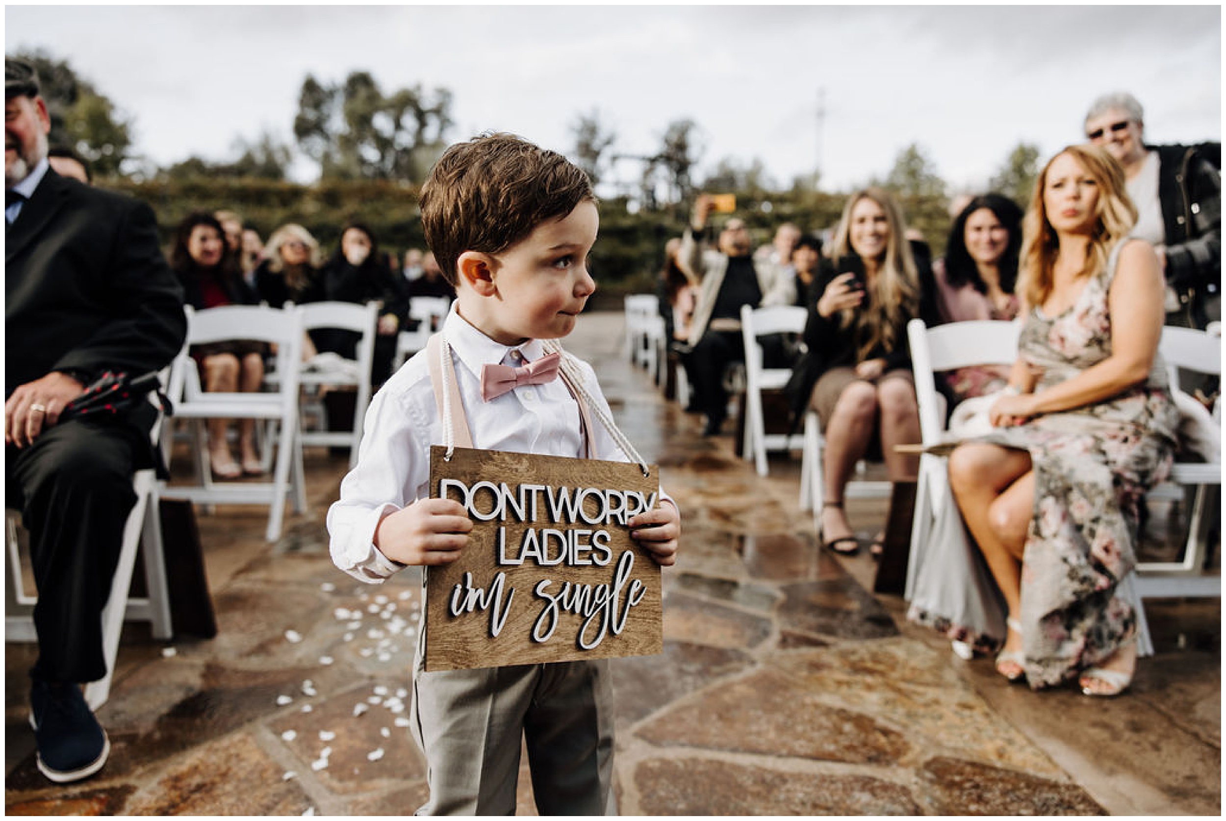 ring bearer walking with sign