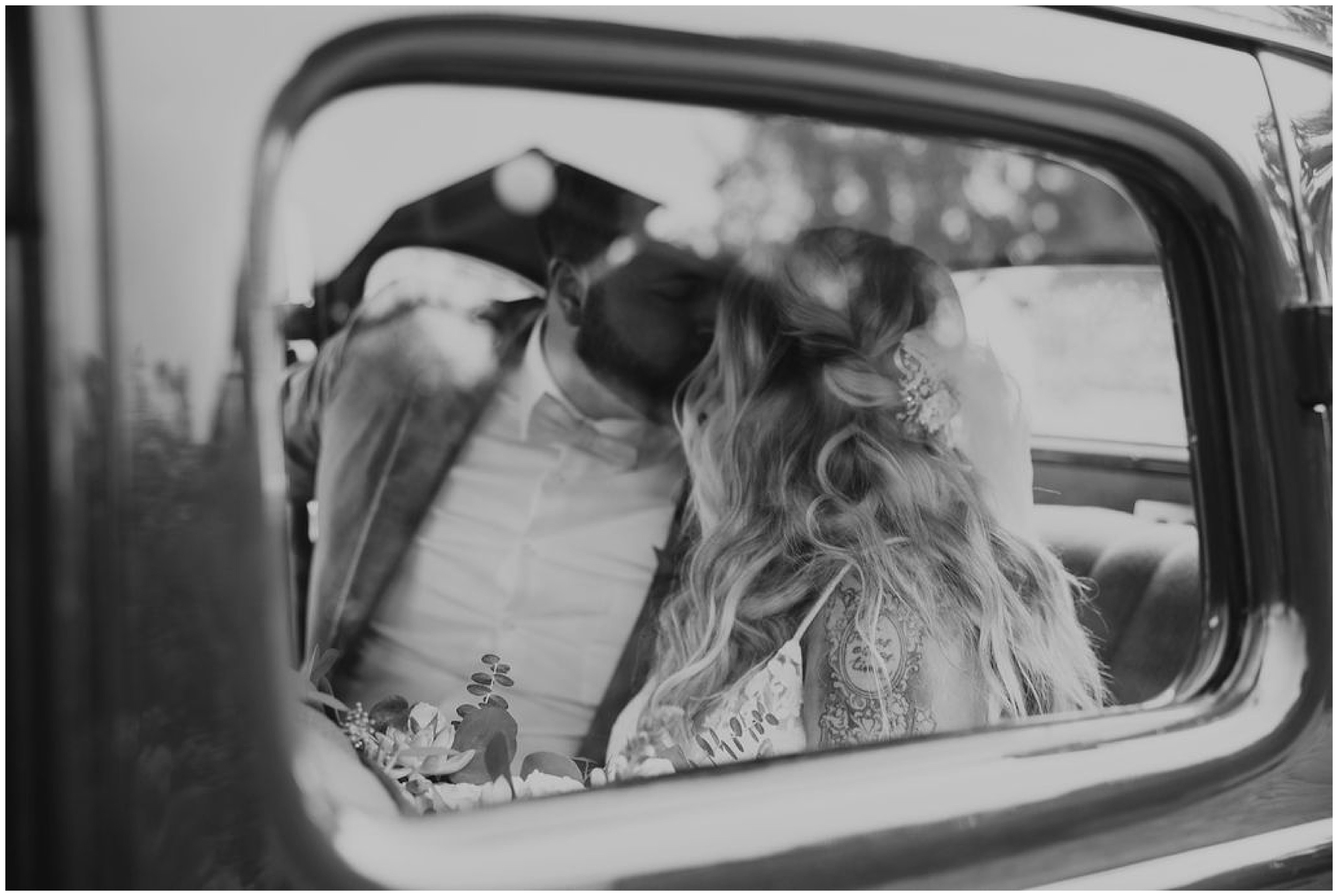 bride and groom kissing through car window