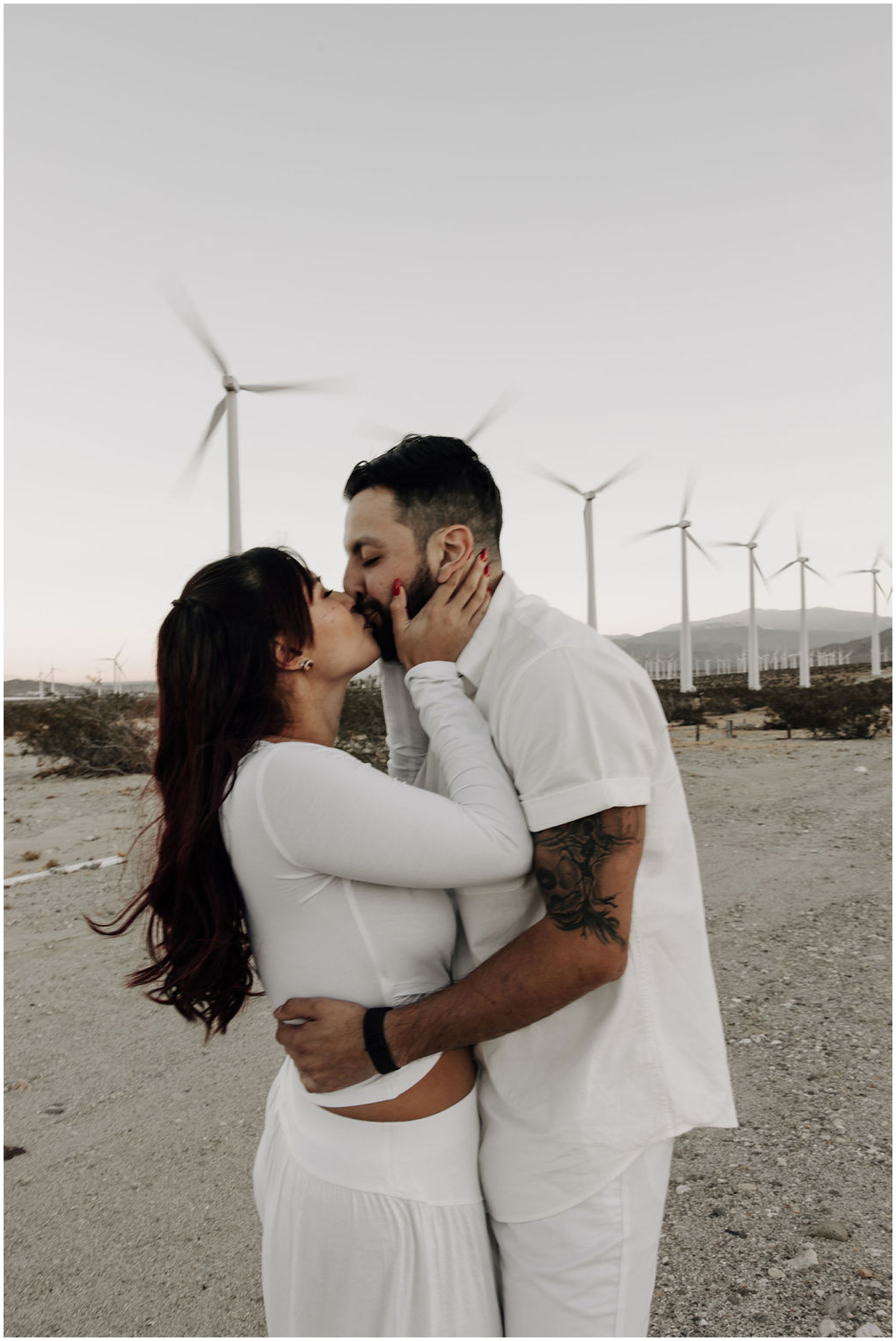 couple kissing by windmills