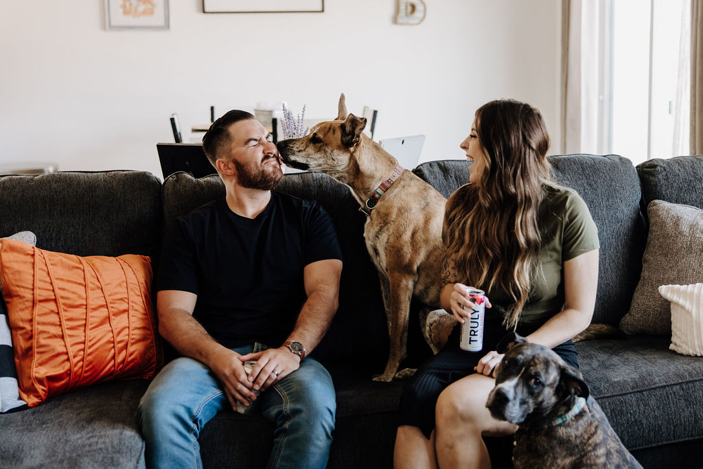 couple sitting on couch with dogs