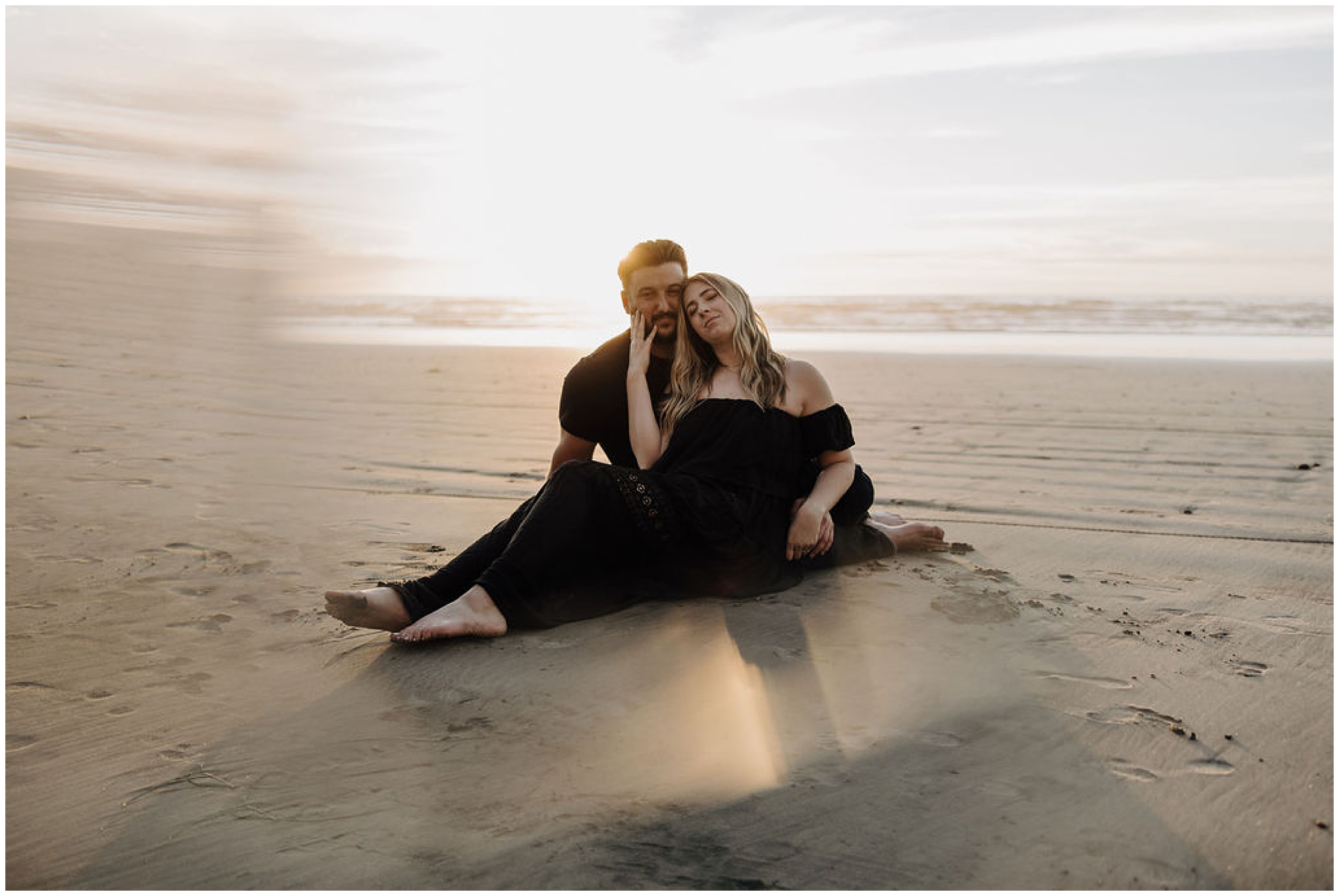 couple sitting on beach at sunset