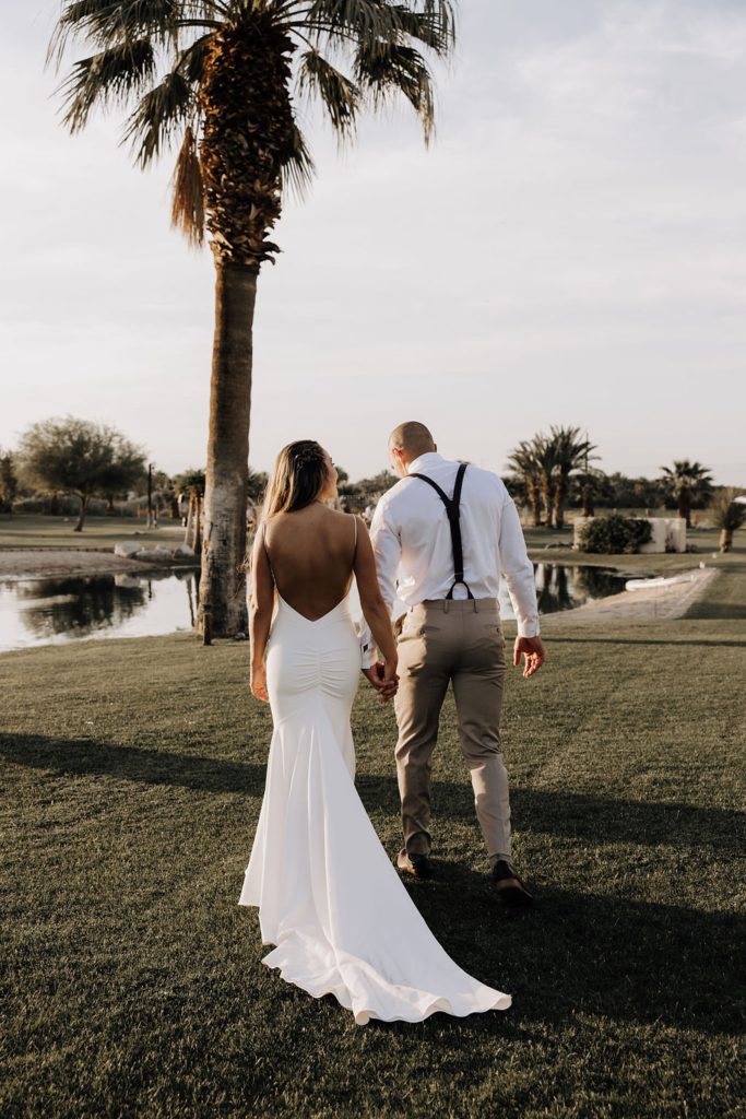 bride and groom walking towards palm tree